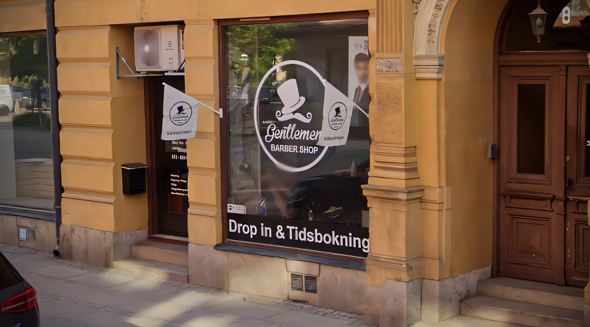 Fasadflaggor på varsin sida om ett stort skyltfönster. Flaggorna är monterade på fasaden - Reklamhuset RINK