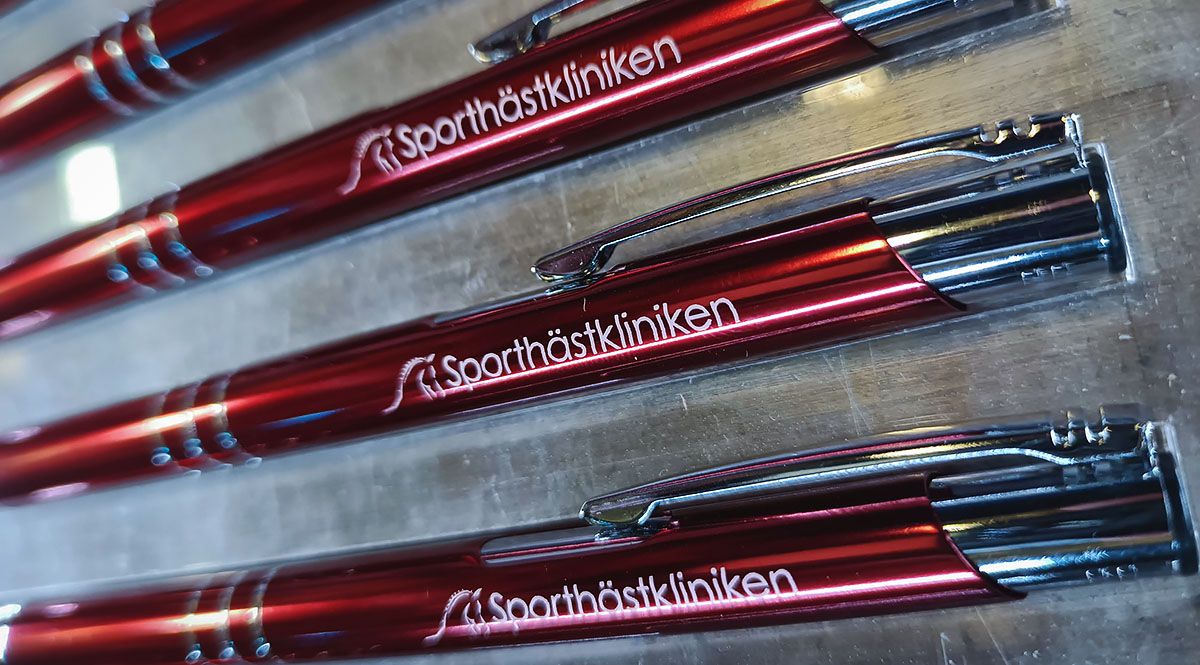 Graverade metallpennor i färgen Burgundy, graverade med Sporthästklinikens logotyp - Reklamhuset RINK